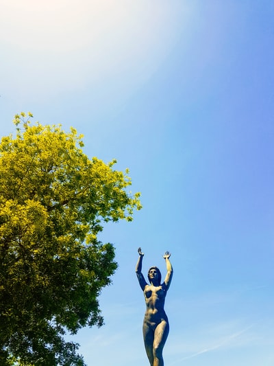 During the day, wearing a black vest and black pants women jumping on the trees
